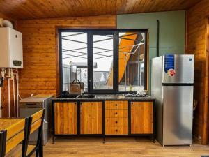a kitchen with a stainless steel refrigerator and a window at Chopan Resort Aparan in Aparan