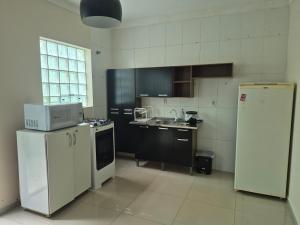 a kitchen with black and white appliances and a refrigerator at Casa Central Super Conforto 78 in Ponta Grossa +10 photos