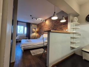 a bedroom with a bed and a brick wall at Apartment Madera in Belgrade