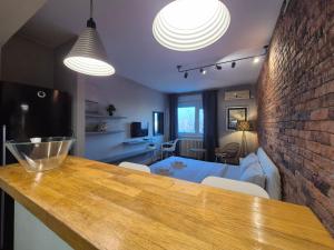 a kitchen and living room with a brick wall at Apartment Madera in Belgrade
