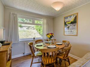 a dining room with a table and chairs and a window at 3 Bed in Carnforth oc-sz425 in Arnside