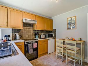 a kitchen with wooden cabinets and a stove top oven at 3 Bed in Carnforth oc-sz425 in Arnside +11 photos
