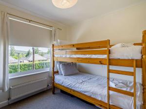 two bunk beds in a room with a window at 3 Bed in Carnforth oc-sz425 in Arnside