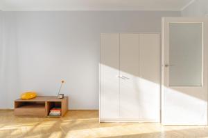 a white closet in a room with a wooden table at Quiet Kraków Nest by Siemaszki 41 in Krakow