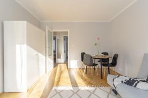 a white living room with a table and chairs at Quiet Kraków Nest by Siemaszki 41 in Krakow