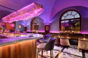 a purple room with a bar with chairs and tables at Hotel Balestri - WTB Hotels in Florence