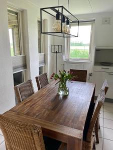 a dining room table with chairs and a vase of flowers at 6 - Persons Forest 223 Bungalow in Ewijk