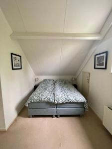 a bedroom with a bed in a attic at 6 - Persons Forest 223 Bungalow in Ewijk +14 photos