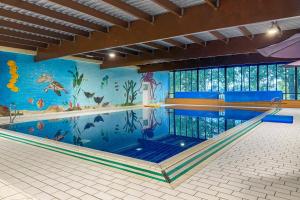 a large swimming pool with a mural on the wall at 6 - Persons Forest 223 Bungalow in Ewijk