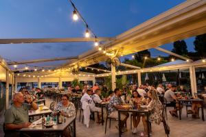 a group of people sitting at tables on a patio at hu Venezia Camping in Town in Marghera