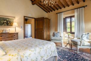 a bedroom with a bed and two chairs at Agriturismo La Frattina in Buonconvento +100 photos