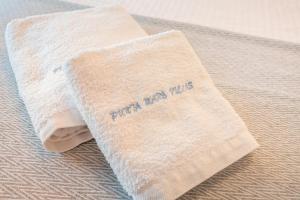 a towel with the words faith never dies on it on a bed at Punta Mare Villas in Karpathos +48 photos