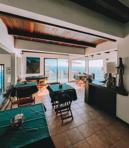 a room with ping pong tables and a view of the ocean at Mar Infinito Guest House in Arraial do Cabo