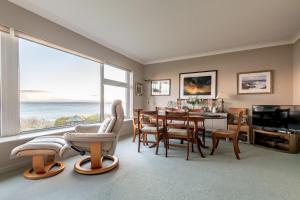 a living room with a table and chairs and a large window at East Vows - Elie in Earlsferry