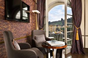 a room with two chairs and a table and a window at Hotel Balestri - WTB Hotels in Florence
