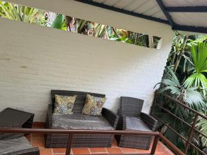 a porch with a couch and chairs on a patio at balcon birds ecopolis in El Queremal +59 photos