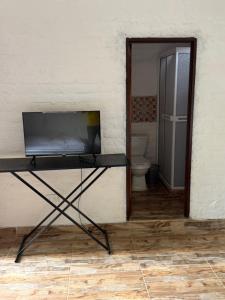 a television on a table in a room with a toilet at balcon birds ecopolis in El Queremal