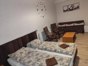 a room with two beds and a table and chairs at Zajazd Kadar in Wisła