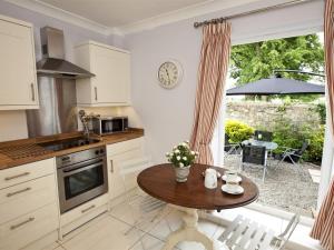 a kitchen with a wooden table and a table and a window at 2 Bed in Richmond oc-g0116 in Hutton Magna