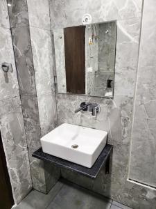a bathroom with a white sink and a mirror at Crestview Inn in Lucknow