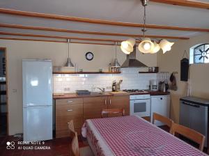a kitchen with a table and a white refrigerator at Gîte de la Gagée in Besmont