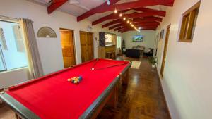 a pool table in a living room with a red cover at Apart Hotel de Alegria in Cusco