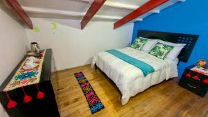 a bedroom with a bed with blue walls and wooden floors at Apart Hotel de Alegria in Cusco +28 photos
