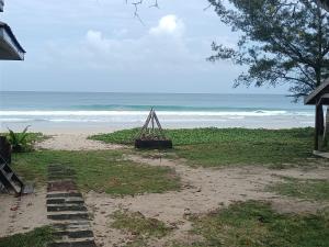 a beach with a wooden structure sitting on the sand at Kudat Beach House 4 in Kudat