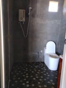 a small bathroom with a toilet and a shower at Kudat Beach House 4 in Kudat