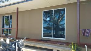 a motorcycle parked in front of a house with a window at Kudat Beach House 4 in Kudat