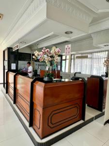 a lobby with a counter with flowers on it at Aurora Hotel Kartini in Cirebon
