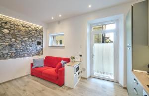a living room with a red couch and a tv at La cà del Pin in Lierna