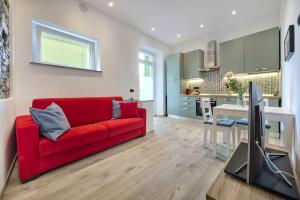 a living room with a red couch and a kitchen at La cà del Pin in Lierna