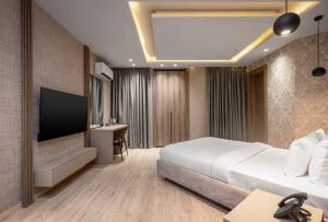 a hotel room with a bed and a flat screen tv at Atlanticblu hotels & Resort in Abuja