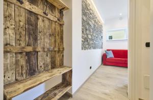 a sliding barn door in a hallway with a red couch at La cà del Pin in Lierna +24 photos