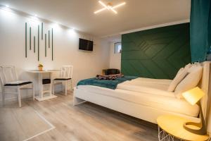 a bedroom with a large bed and a table at Royal Gold Apartman in Kiskunhalas