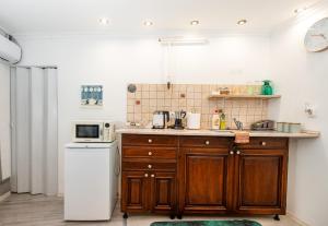 a kitchen with a sink and a refrigerator at Royal Gold Apartman in Kiskunhalas +21 photos