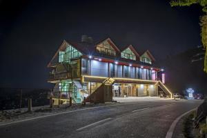 a house is lit up at night at Hotel Mountain Nest in Nārkanda