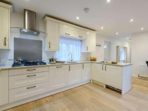 a kitchen with white cabinets and a stove top oven at 3 Bed in Wareham oc-81369 in Corfe Castle