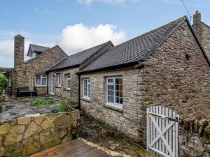 a stone cottage with a white fence in front of it at 3 Bed in Wareham oc-81369 in Corfe Castle