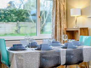 a table with blue plates and wine glasses on it at 3 Bed in Wareham oc-86239 in Corfe Castle +17 photos