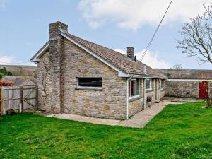 a stone house with a grass yard in front of it at 3 Bed in Wareham oc-86239 in Corfe Castle