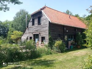 an old wooden house with a red roof at Gîte de la Gagée in Besmont