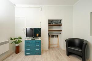 a living room with a tv and a black chair at Royal Gold Apartman in Kiskunhalas