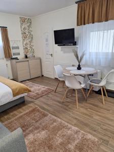 a bedroom with a bed and a table and chairs at Várfal apartman I in Eger