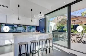 a kitchen with a bar with stools in it at SUPERBE Villa PISCINE moderne - Cap brun - plage de Toulon in Toulon