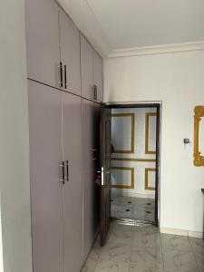 a hallway with white cabinets and a door to a room at Otijoe Premier Hotel 2 in Port Harcourt
