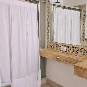 a bathroom with a shower curtain and a mirror at Casa Clara in Rufino +34 photos