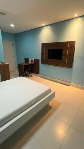 a bedroom with a bed and a tv on the wall at Luxu's Motel in Tucano
