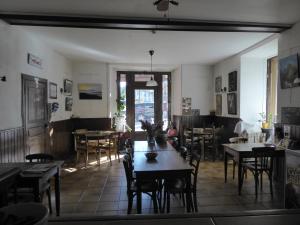 a restaurant with tables and chairs in a room at Auberge l'Escaleta in Seix
